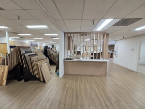 Showroom area with raw cabinet stacks and a wood-slat partition