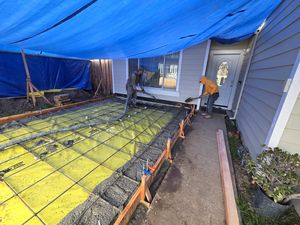 Team Working Alongside the House to Pour Concrete