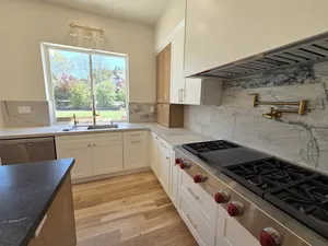 9Builders: Elegant Kitchen Island with Marble Countertops and Open Concept Layout