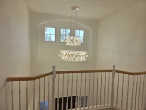 9Builders: Open Living Area with Ample Natural Light and Modern Lighting Fixtures