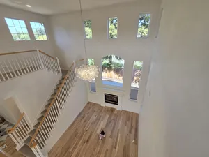 9Builders: Elegant Staircase and Custom Lighting in a Bright Entryway