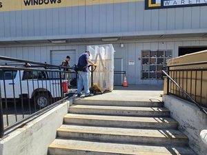 Worker moving wrapped material at the Contractors' Warehouse loading entrance