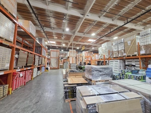 Wide warehouse aisle with cabinets, countertops and orange industrial racking