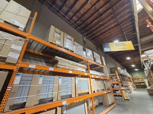 Wide warehouse view with boxed cabinets on pallet racks