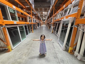 Young visitor with arms wide between window racks