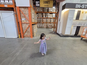 Young visitor walking toward Cabinets and In-Stock display