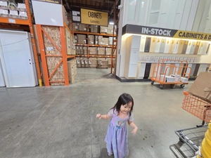 Young visitor walking past the In-Stock Cabinets & Doors display